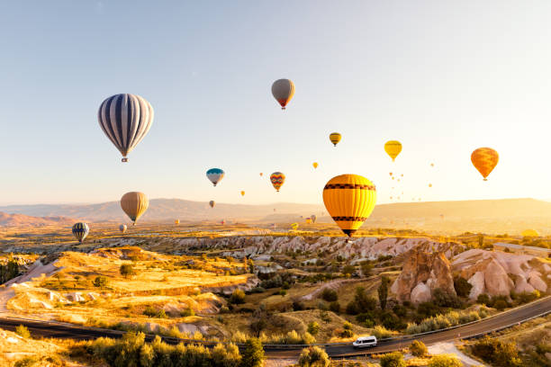 hot air balloons over cappadocia at sunrise，turkey - cappadocia hot air balloon turkey basket imagens e fotografias de stock