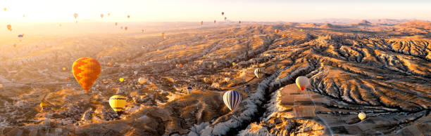 aerial view of hot air balloons over cappadocia at sunrise，turkey(panorama xxl) - cappadocia hot air balloon turkey basket imagens e fotografias de stock