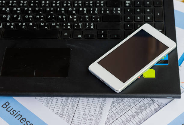 istock Image of smartphone on notebooks on document  charts at office. 1044719162