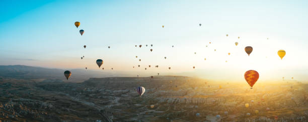 aerial view of hot air balloons over cappadocia at sunrise，turkey(panorama xxl) - cappadocia hot air balloon turkey basket imagens e fotografias de stock