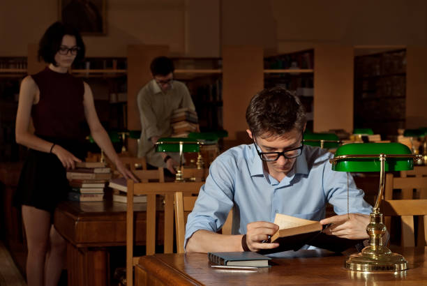 istock guy with books in the library 1044721602