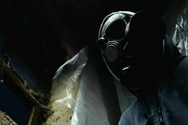 istock Man in a gas mask dark background 1044722848