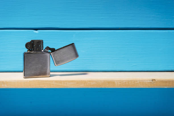 istock Gasoline lighter, metal lighter on a blue wooden table background 1044725980