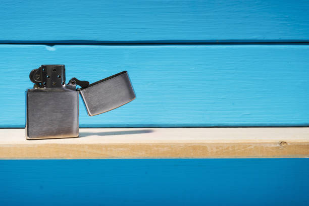 istock Gasoline lighter, metal lighter on a blue wooden table background 1044731990