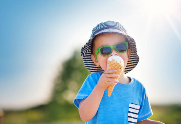 happy child eating ice cream outdoors in summer - lanche da tarde imagens e fotografias de stock
