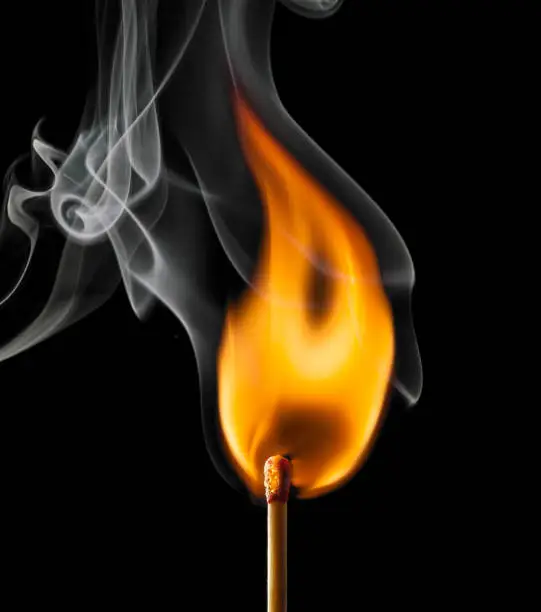 Photo of Ignition of a match, with smoke on dark background