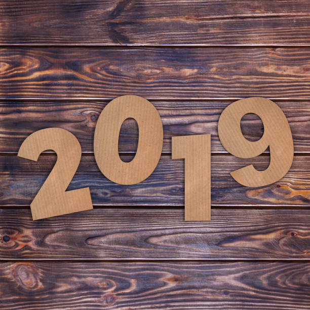 istock Cardstock Numbers 2019 Happy New Year Sign over table. 3d Rendering 1044744536