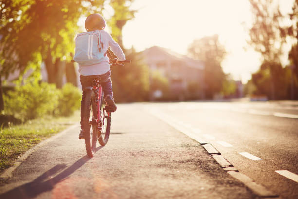 child on a bicycle child on a bicycle at asphalt road in early morning. Boy on bike in the city bicycle cycling school child stock pictures, royalty-free photos & images