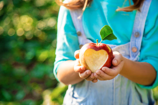 dziecko z jabłkiem. selektywne skupienie. ogr�ód. - apple eating little girls green zdjęcia i obrazy z banku zdjęć