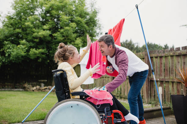 papa de multitâche avec fille handicapée heureuse - disabled teenager adolescence physical impairment photos et images de collection