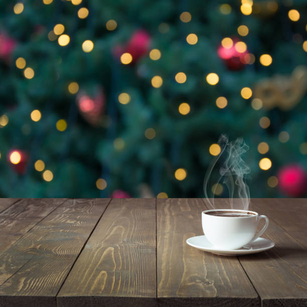 värmande kopp hett svart kaffe på träbord i café. suddig julgran som bakgrund. christmas time. bild för visning eller montage dina produkter. - julfika bildbanksfoton och bilder