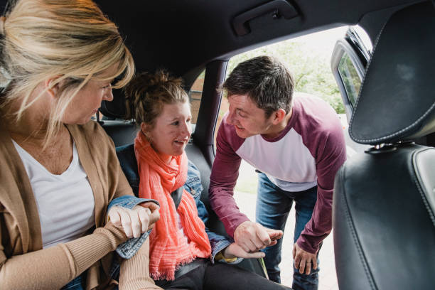 istock Parents Placing Disabled Daughter in the Car 1044763370
