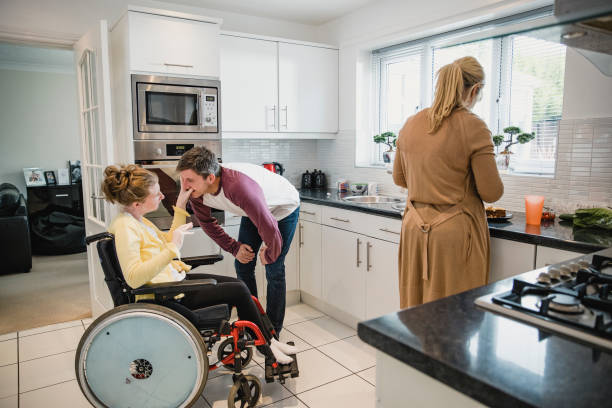 famille avec une fille handicapée dans la cuisine - disabled teenager adolescence physical impairment photos et images de collection