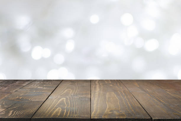 istock Wooden tabletop and blurred light white bokeh. Christmas background. 1044763832