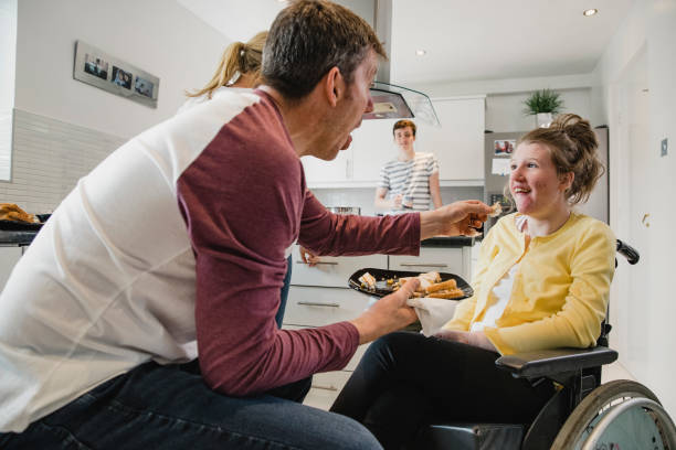istock Father Feeding his Disabled Daughter Lunch 1044764220