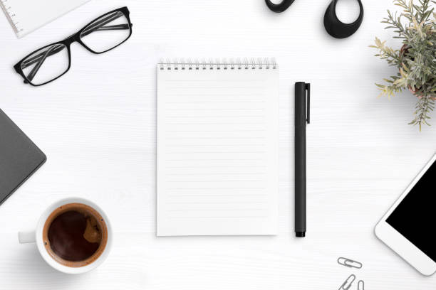 istock Empty writing pad on office desk surrounder with office supplies. Top view composition. 1044768106