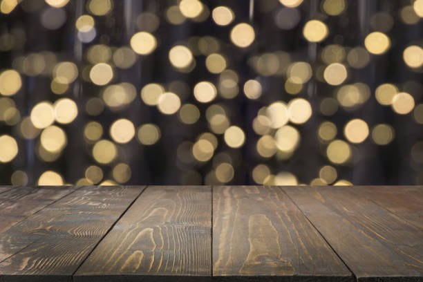 istock Blurred gold garland and wooden tabletop as foreground. Image for display or montage your christmas products. 1044769058