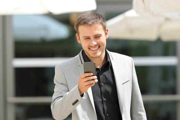 istock Front view of an executive walking using a phone 1044773434