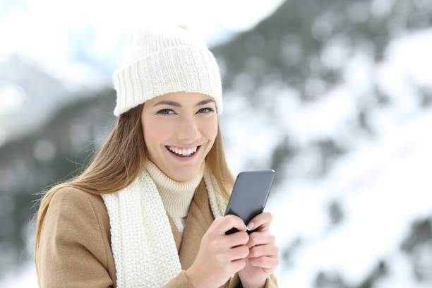 istock Woman looking at camera holding a phone in winter 1044774802