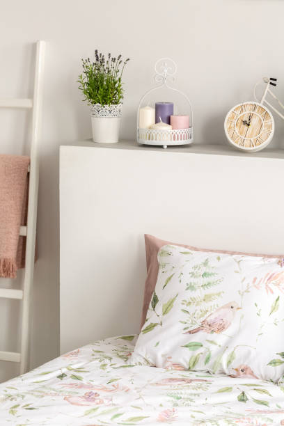 istock Patterned pillow on bed with headboard with plant in bright bedroom interior. Real photo 1044781800