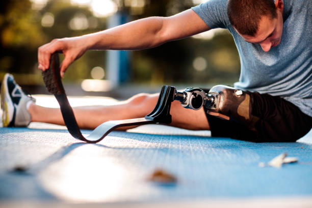 Disabled man stretching outdoors stock photo