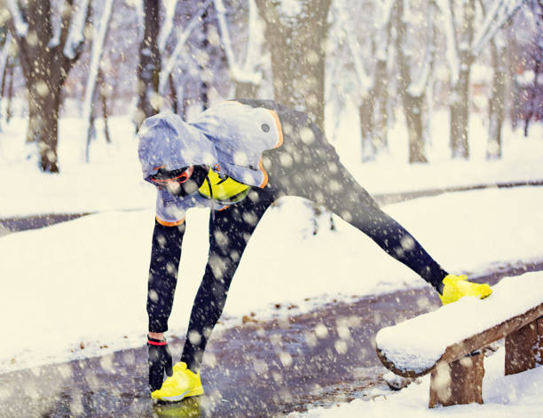 istock Sportsman stretching on a bench in strong winter time. 1044784008