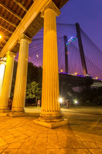 The iconic Princep ghat of Kolkata with Vidyasagar bridge towering in the backdrop, boasting its beauty right after sunset during the magic hour.