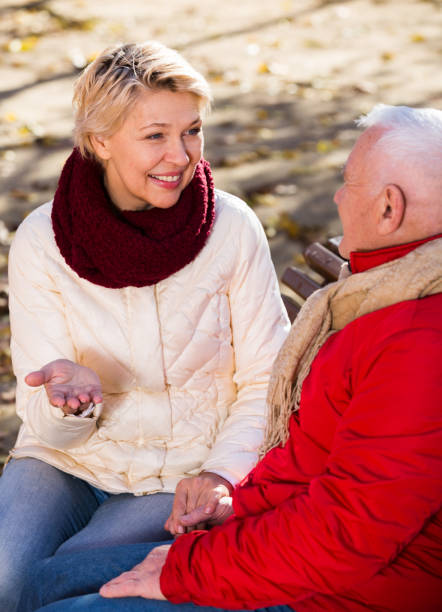 istock Mature couple talking in park 1044795624
