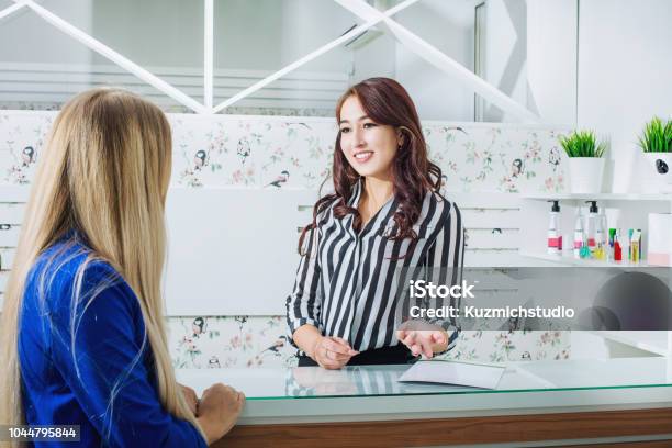 Schöne Junge Empfangsdame Mädchen Mit Einem Lächeln An Der Rezeption Trifft Kunden Im Salon Stockfoto und mehr Bilder von Friseursalon