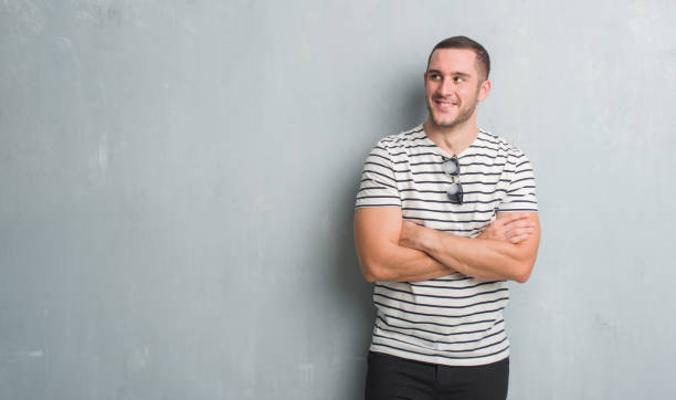 istock Young caucasian man over grey grunge wall smiling looking side and staring away thinking. 1044799364
