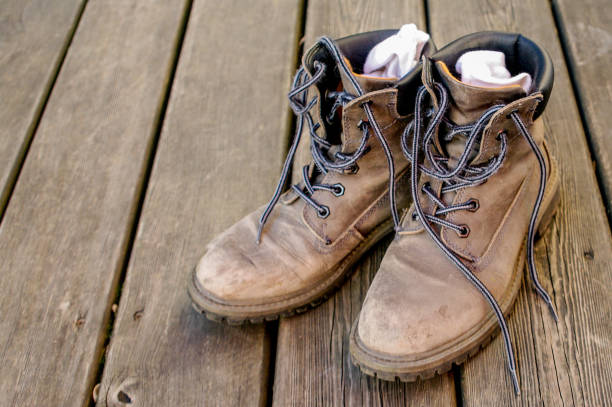 istock Old Dirty Brown Boots On Wooden Surface 1044807766