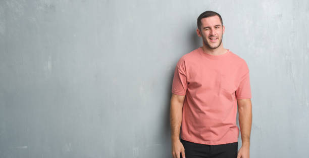 istock Young caucasian man over grey grunge wall winking looking at the camera with sexy expression, cheerful and happy face. 1044812180
