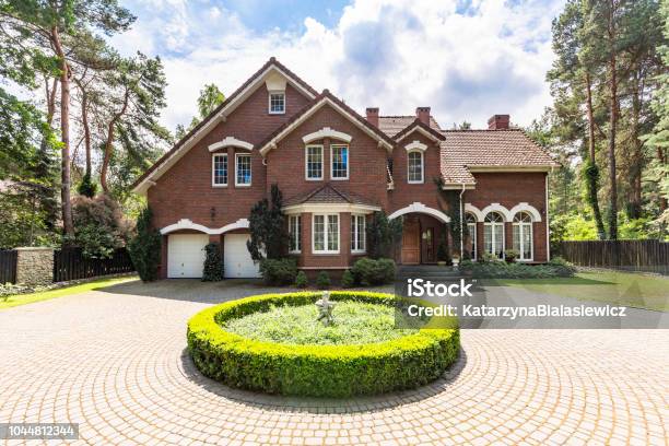 Front View Of A Driveway With A Round Garden And Big English Style House In The Background Real Photo Stock Photo - Download Image Now