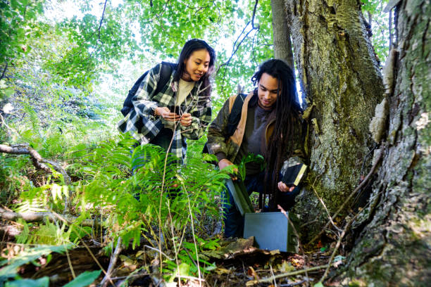 istock Geocaching.  A millennial couple out geocaching in the woods 1044816250