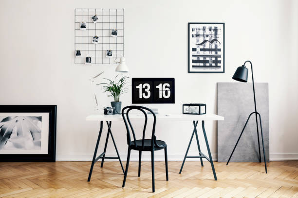istock Black chair at white desk with desktop computer and plant in modern workspace interior. Real photo 1044817046