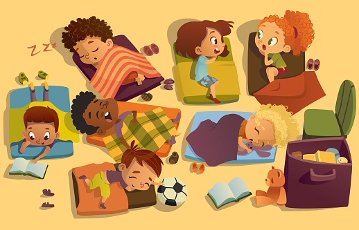 Nap time in the kindergarten. Group of multiracial girls and boys have a nip time at a colorfill nap mats. Preschool dream time. Two girls gossip during daytime sleep.