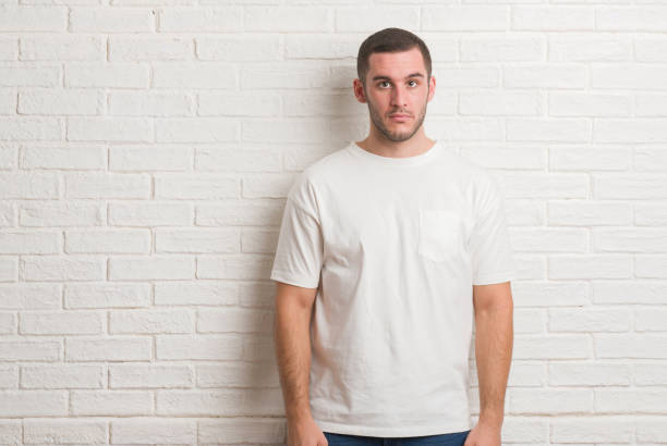 istock Young caucasian man standing over white brick wall depressed and worry for distress, crying angry and afraid. Sad expression. 1044824370