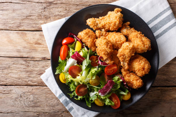 istock deep-fried chicken wings in breadcrumbs and fresh vegetable close-up. horizontal top view 1044828126