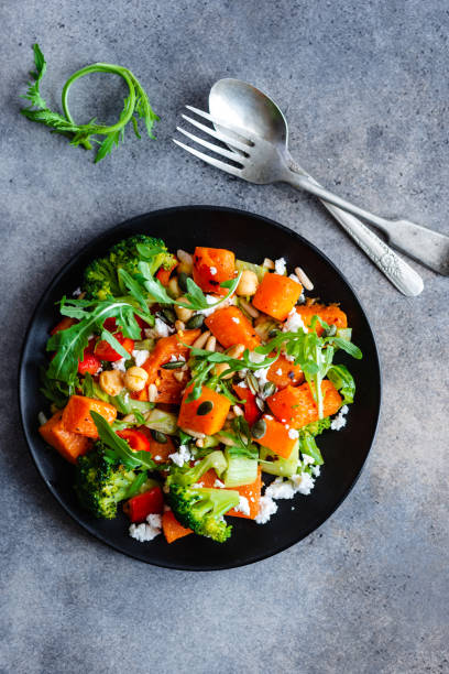 istock Roasted Pumpkin salad with vegetable and herb on textured background 1044829760