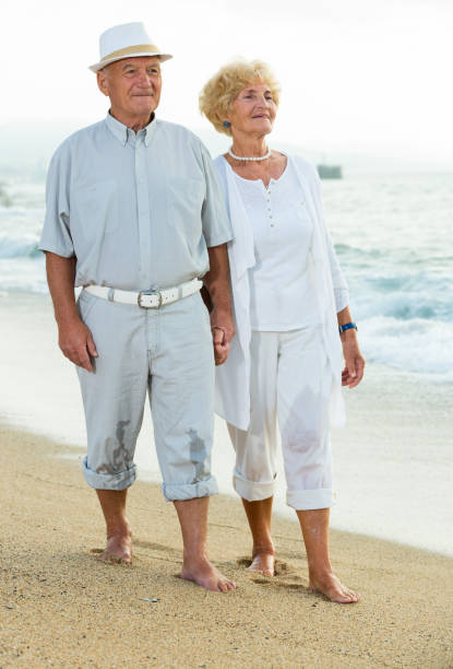 istock cheerful pensioners walking barefoot together 1044832698