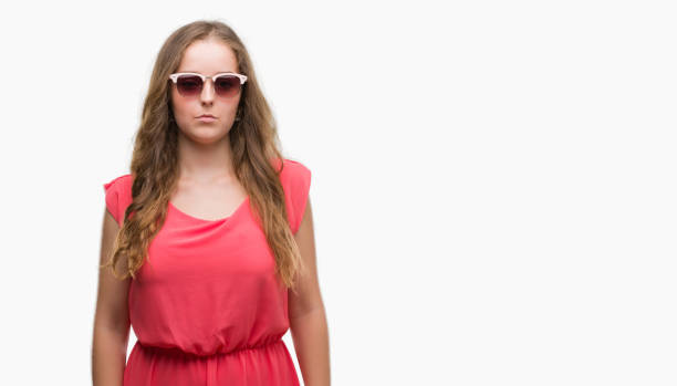 istock Young blonde woman wearing pink sunglasses with a confident expression on smart face thinking serious 1044837276