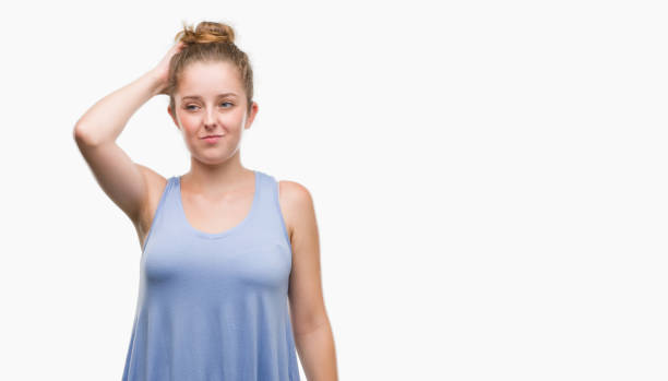 Young blonde woman confuse and wonder about question. Uncertain with doubt, thinking with hand on head. Pensive concept.
