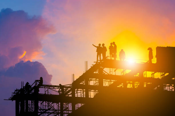 silhueta de engenheiro e trabalhador no canteiro de obras, canteiro de obras com traçado de recorte ao pôr do sol no tempo da noite. - crane tower crane construction silhouette - fotografias e filmes do acervo