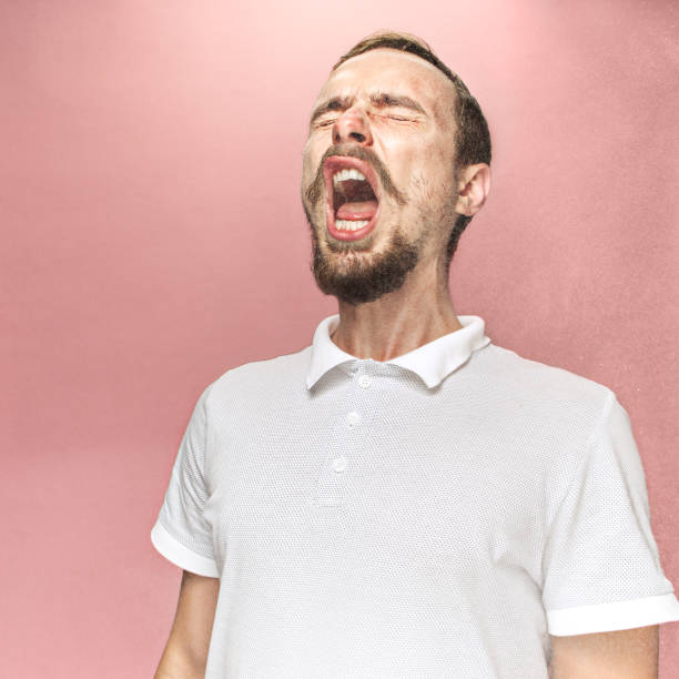 istock Young handsome man with beard sneezing, studio portrait 1044848048