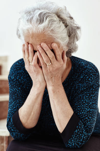 istock Old woman sitting on steps and crying 1044848432