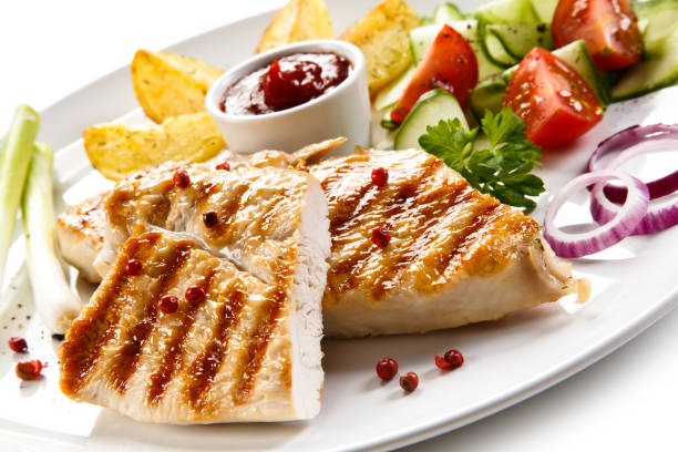 istock Grilled chicken breast and vegetables on white background 1044851206