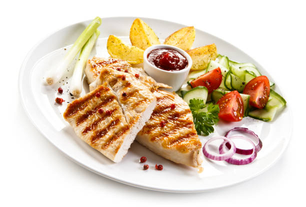 istock Grilled chicken breast and vegetables on white background 1044855302