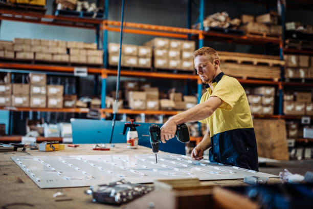 istock Ginger Australian guy working with drill in factory 1044855486