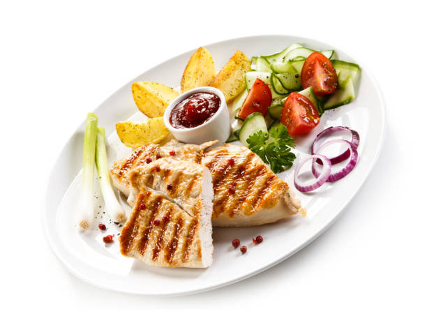 istock Grilled chicken breast and vegetables on white background 1044855900