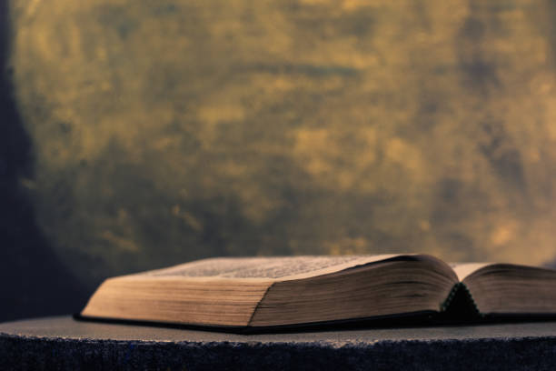 istock Open Holy Bible on a stone round table. Beautiful Gold background. Religious concept. 1044856236